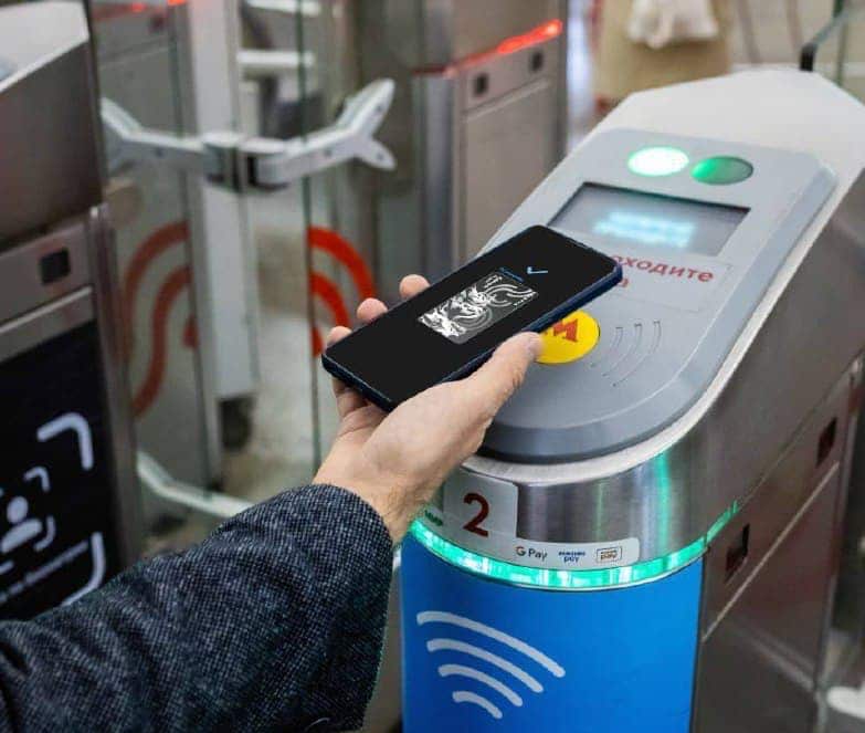 Hand with virtual Troika card at Moscow Metro gate.